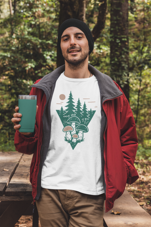 t-shirt-mockup-featuring-a-man-holding-a-20-oz-travel-mug-in-the-woods-30486.png